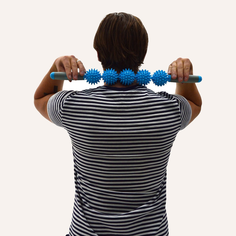 Mand masserer nakke og skuldre med TriggerRoll massagerulle