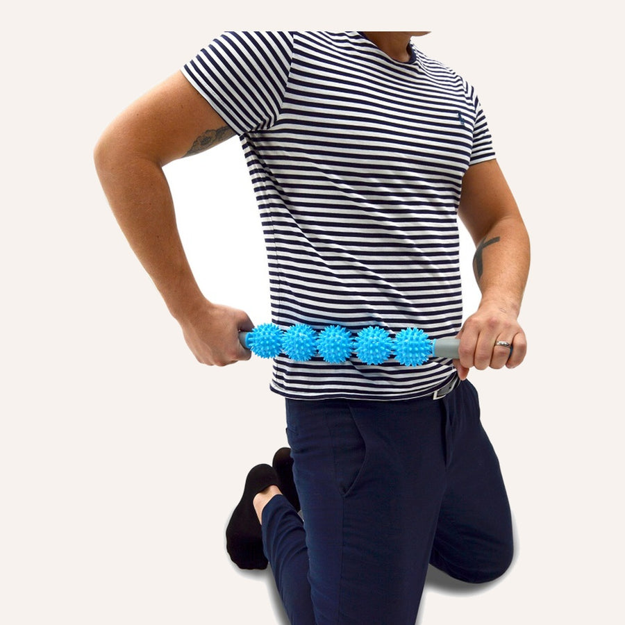 Mand masserer lænden med TriggerRoll massagerulle