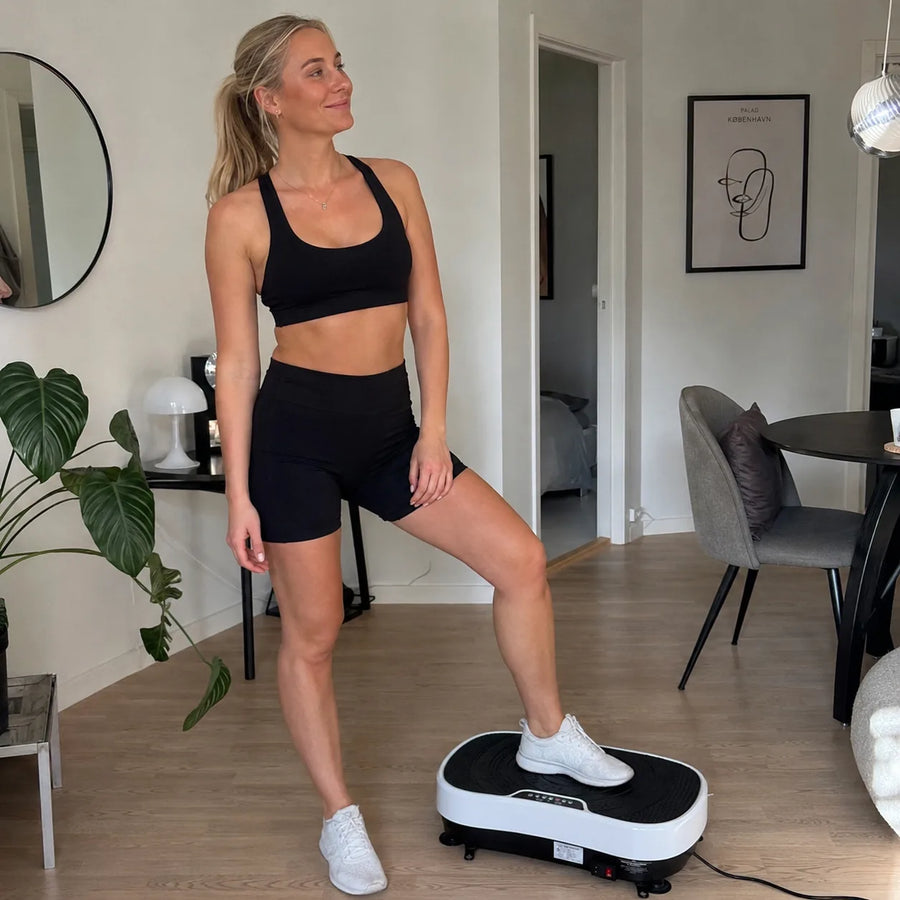 Kvinde træner hjemme på Feevra Vibrationsplade