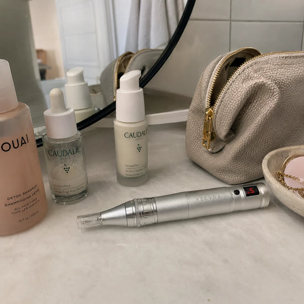 Feevra Microneedling Dermapen ved siden af serum og makeuptaske